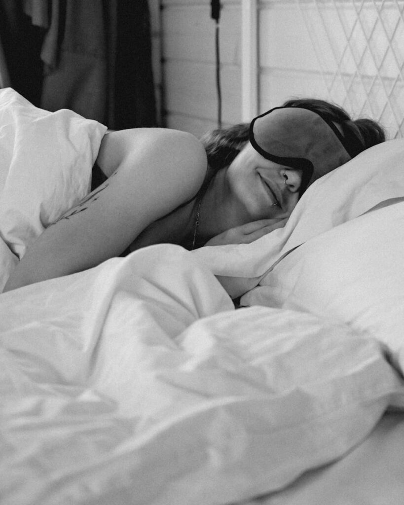 Woman Sleeping in Bed with Sleeping Mask on