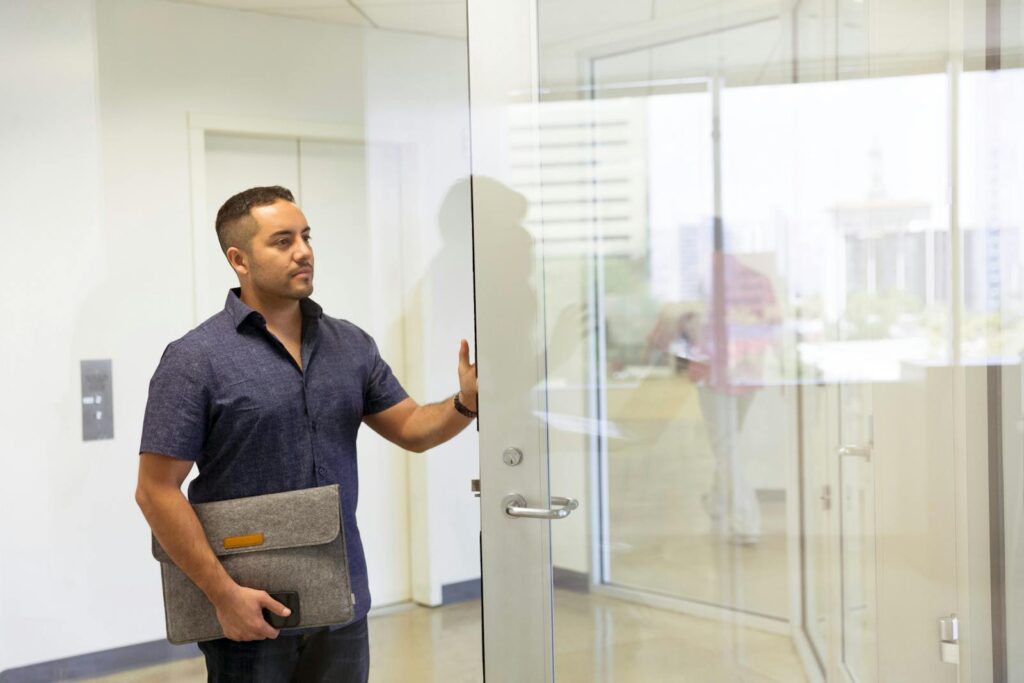 Man Standing Next to Glass Door