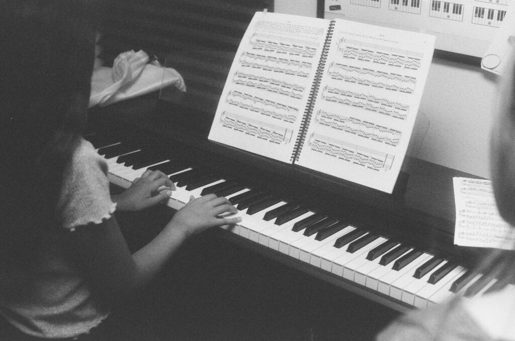 Two children learning to play the piano together.